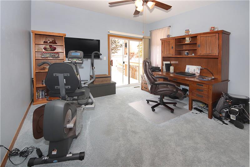 Main level office (could be used as a bedroom) with ceiling fan and closet and provides a walk-out to the back deck