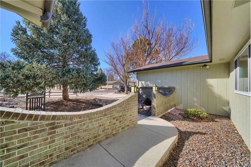 Brick enclosed front walkway to covered entry.