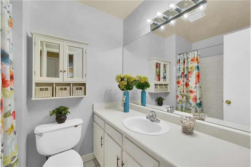 The full hall bath has tile floors, a vanity, cabinet over the toilet, and tub/shower.