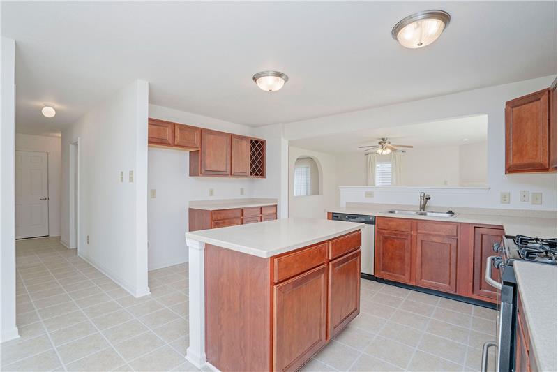 Center island provides additional storage and counter space. Ceramic tile flooring throughout.