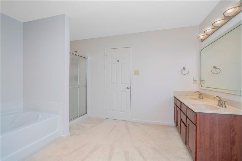 En-suite owner's bathroom features double sink vanity with storage, separate shower and soaking tub.