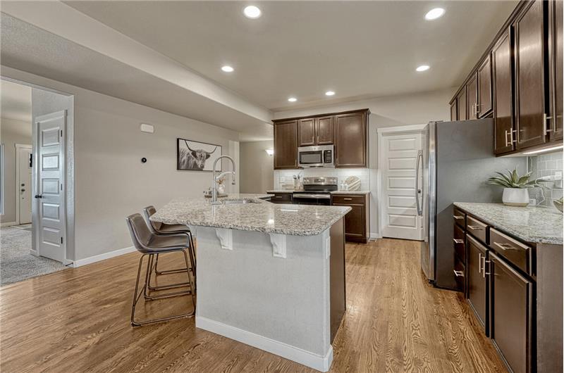 Gourmet Island Kitchen with breakfast bar, pantry, stainless steel appliances, and espresso cabinets with granite countertops.