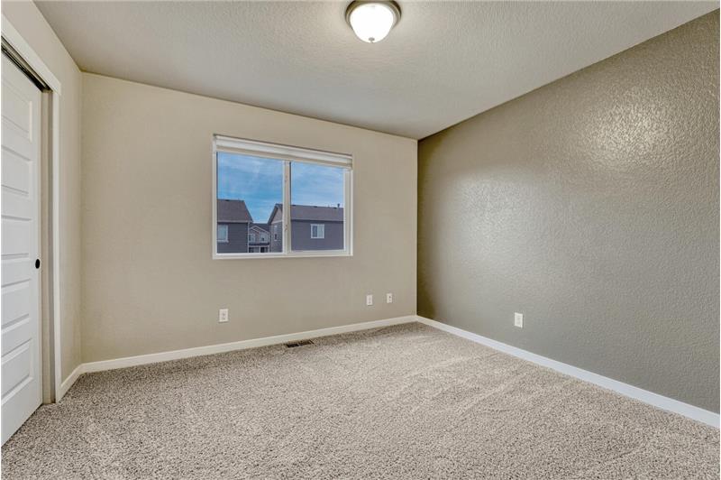 Upper Level Bedroom #1 has neutral carpet, a generous closet, and window.