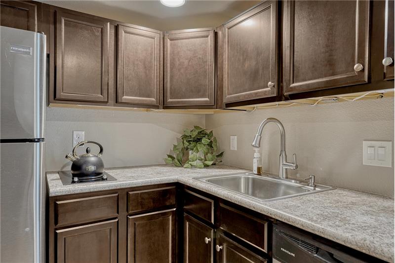 Espresso cabinets with stainless steel sink and lots of counterspace.