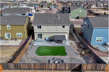 Aerial rear view of home and fenced backyard.