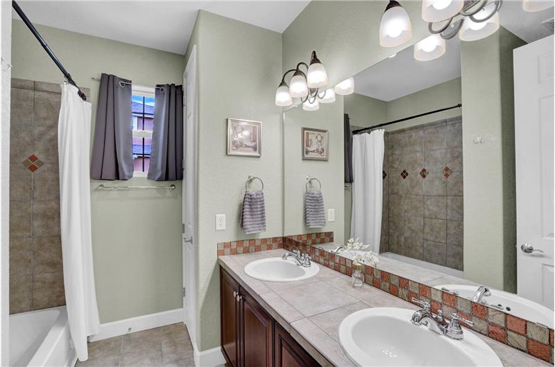 Full Hall Bathroom with dual sink vanity & tiled tub/shower