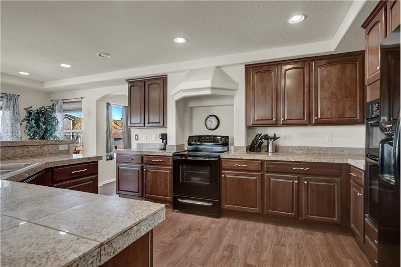 Large, inviting Kitchen that offers recessed lighting, a walk-in pantry, cabinets w/granite tile countertops & pull-out drawers