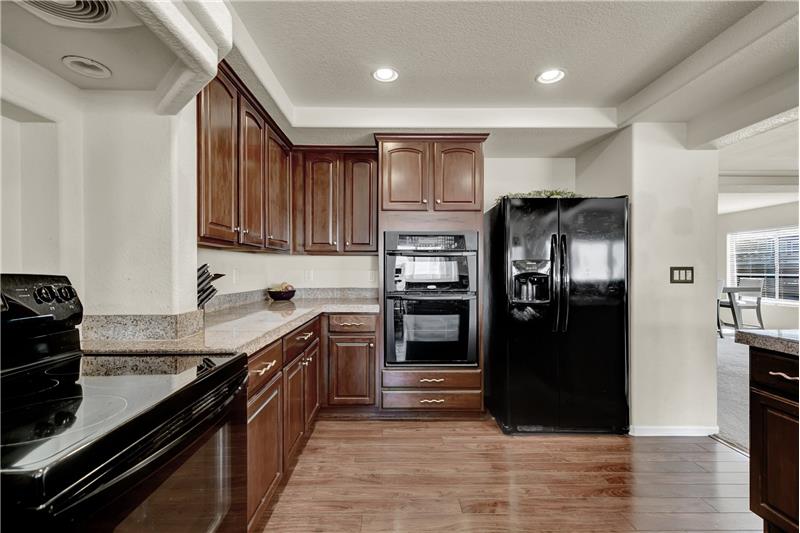 Appliances include a smooth top range oven, dishwasher, built-in microwave & oven, & side by side refrigerator
