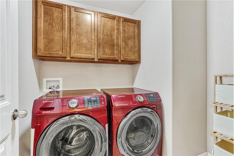 Main level laundry room with cabinets. Washer and Dryer stay!