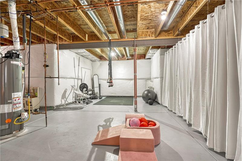 The unfinished basement is ready for expansion with electrical and plumbing already installed for a bathroom.