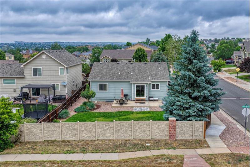 Aerial rear view of home and fenced backyard.