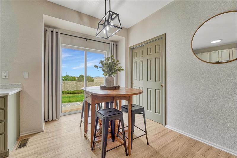 Dining Area with modern light fixture, pantry closet, and slider to the backyard patio.