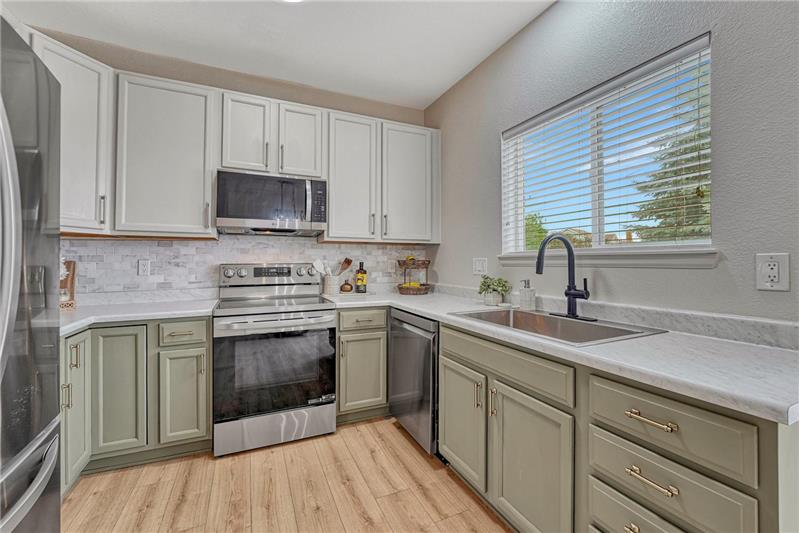 Appliances include a smooth top range oven, built-in microwave oven, dishwasher, and French door refrigerator.