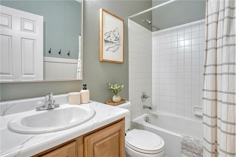 Main Level Full Bathroom with vanity, mirror, and tub/shower.