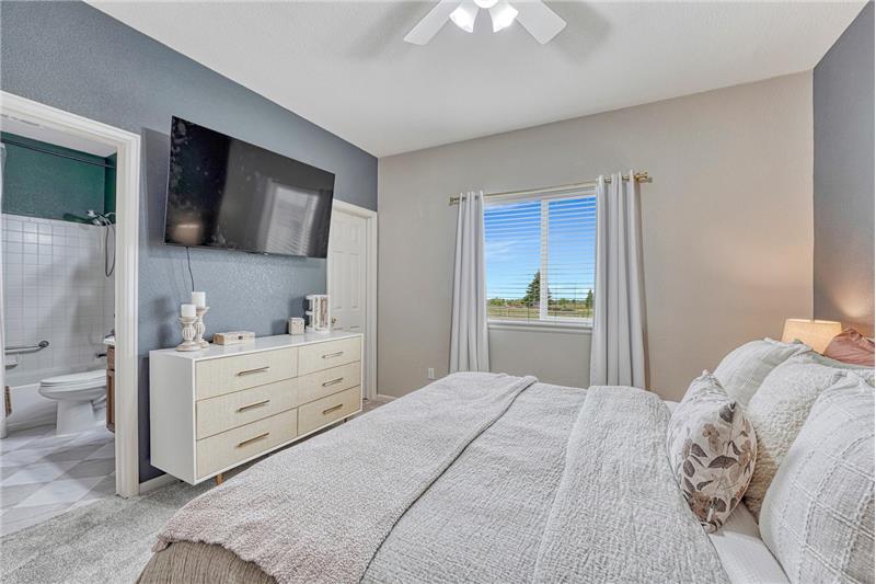 The primary suite provides a peaceful retreat with designer finishes, a walk-in closet, and adjoining bathroom.
