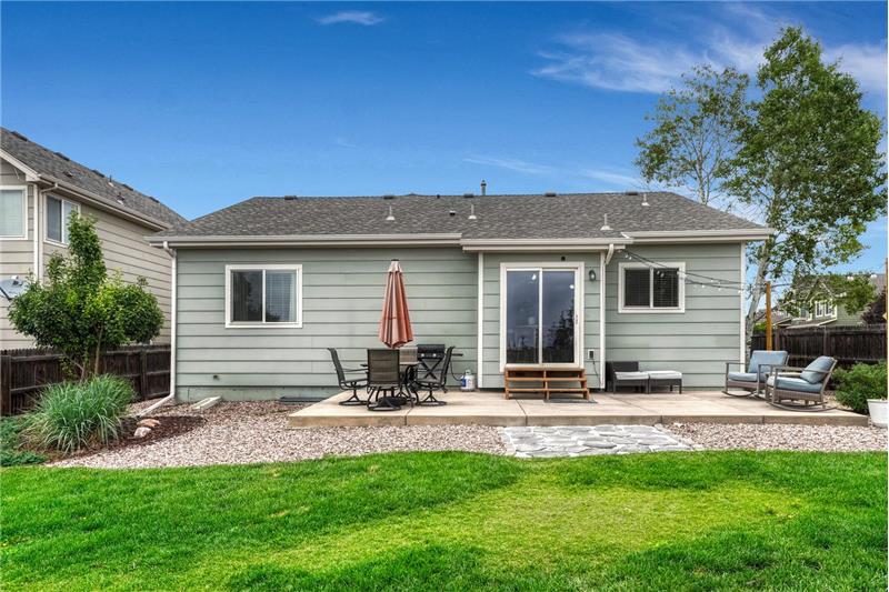The fenced backyard boasts mature landscaping, lush grass, rock gardens, auto sprinklers, & a spacious patio.