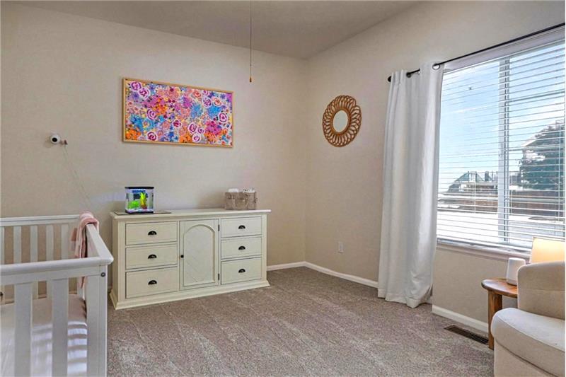 Main Level Bedroom #1 with neutral carpet and lighted ceiling fan.
