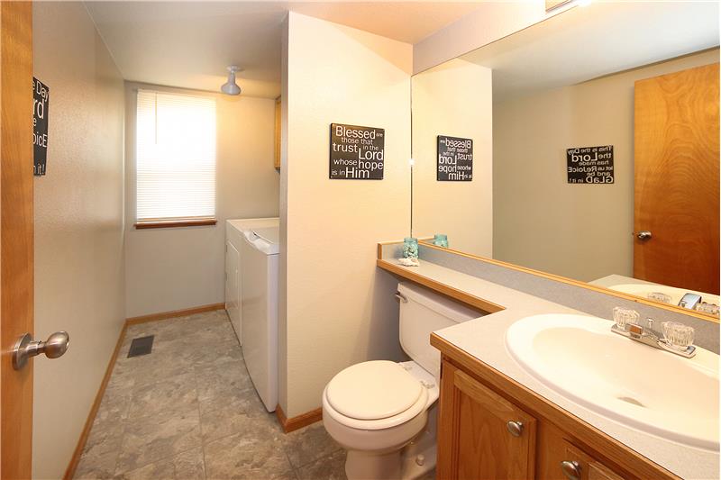 Main level half bath and laundry space with window