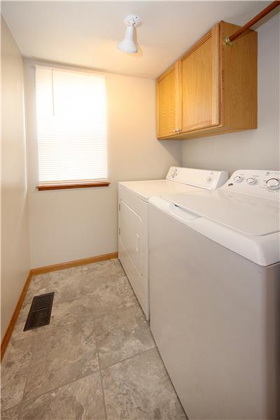 Laundry space with overhead cabinets