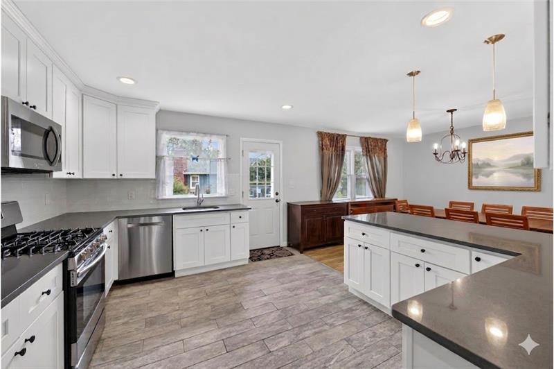 Open floor plan living with an updated kitchen, center island, and seamless access to the deck and backyard