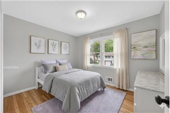 Spacious room featuring wood-finish flooring, light grey wall paint, and a multi-pane window with white trim