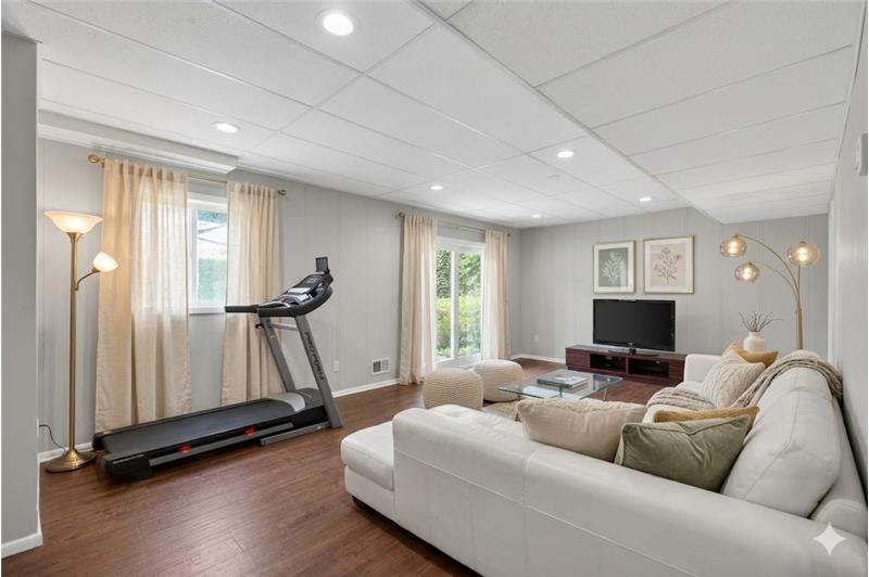 Versatile lower-level recreation space offering endless flexibility for entertaining, work, wellness, or everyday living