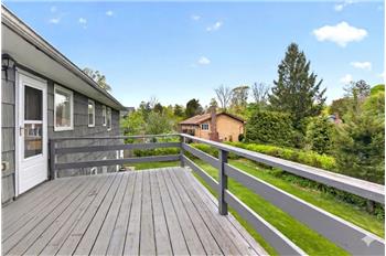 Enjoy summer barbeques on the expanded deck overlooking park- like backyard