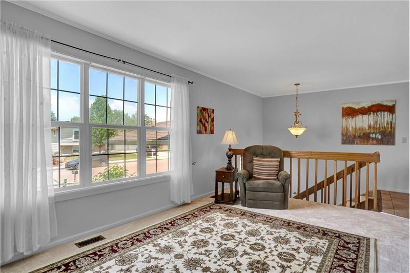 View of the Entry up to the formal Living Room with large picture window and neutral carpet