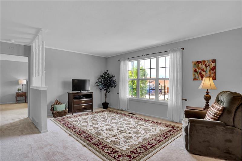 The formal Living Room has neutral carpet and a large picture window with views of the front yard