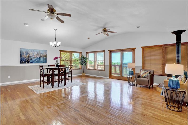 The formal Dining Room features wood floors, two lighted ceiling fans, and French glass doors to the expanded deck