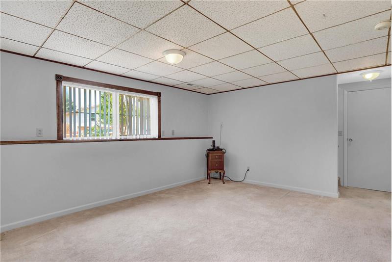 Lower-level Office/Rec Room with neutral carpet and window to bring in abundant natural light