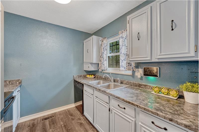 Kitchen with abundant cabinetry, window over the kitchen sink, and included appliances
