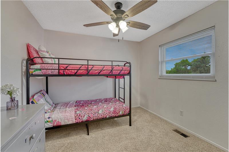 Secondary bedroom on upper level with fresh paint, new blinds, and ceiling fan
