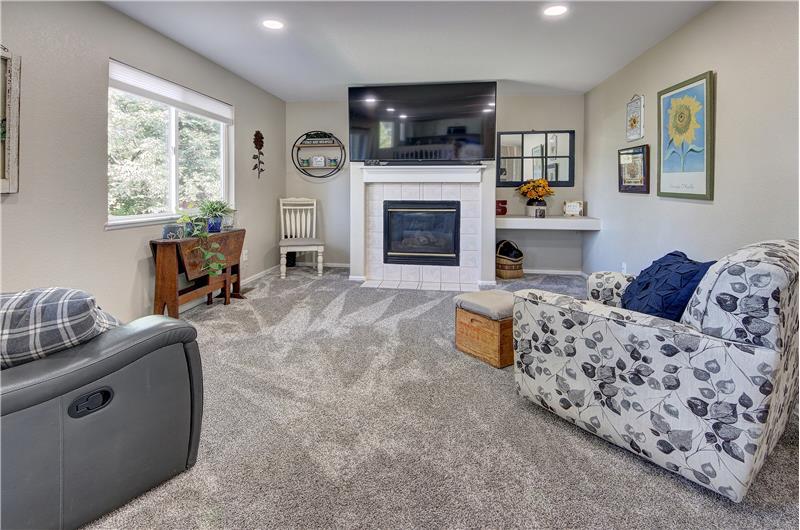 Lower-level Family Room with neutral carpet, recessed lighting, a gas fireplace, and built-in shelves