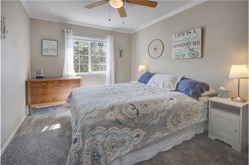 Upper-level Bedroom #2 with neutral carpet and lighted ceiling fan