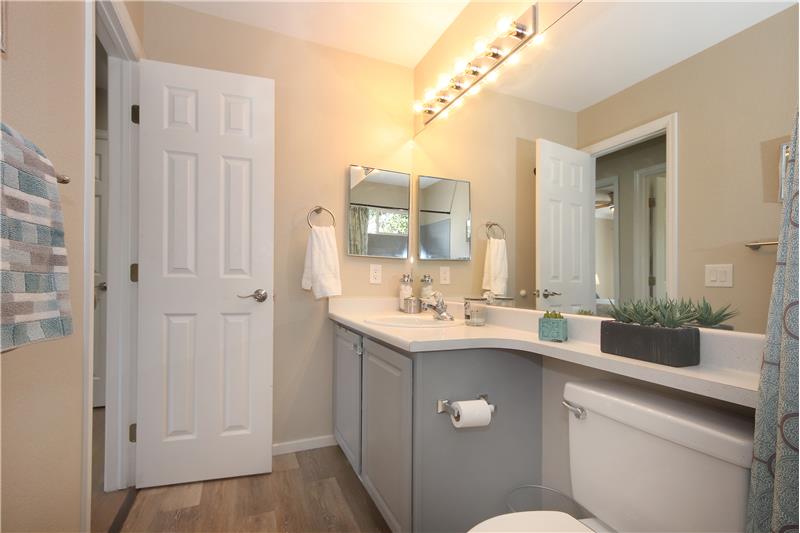 Upper-level full Hall Bathroom with luxury vinyl plank floors, a vanity, and tiled tub/shower