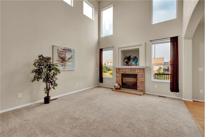 ML Family Rm w/neutral carpet, soaring ceilings, lighted CF, entertainment nook, & gas log FP