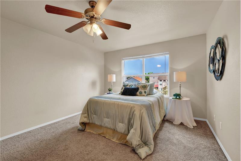 The vaulted Master Bedroom features a lighted ceiling fan and neutral carpet