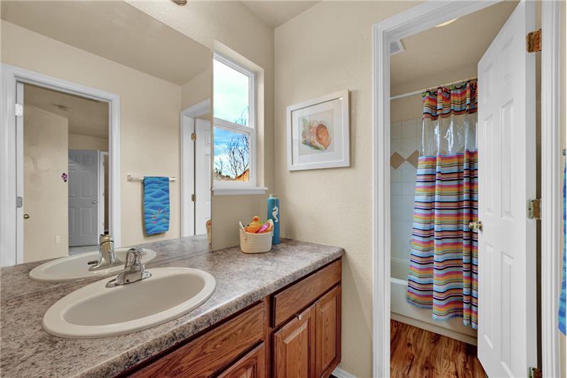 Jack n Jill Bathroom w/a new luxury vinyl plank floor, vanity, and a tub/shower