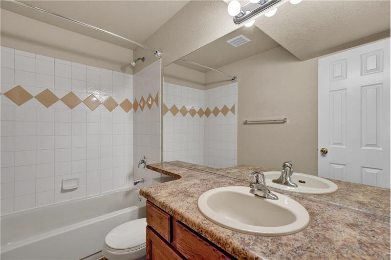 Basement Bathroom with vanity and tiled tub shower