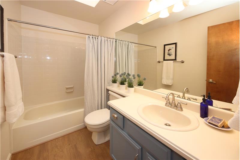 Full bath on main level with updated flooring and a skylight