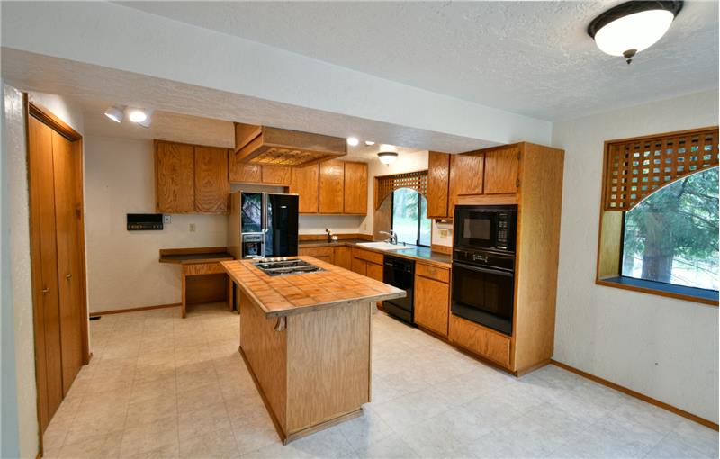 Island gives you extra counter space and storage.  A pantry to the left. Tall cabinets provide more room. Room for coffee bar?