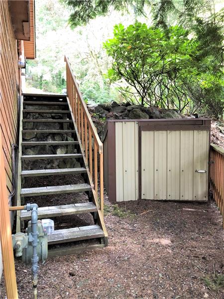 The stairs leading to street and shed nestled next to them.