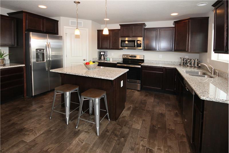 Awesome kitchen with granite counter tops, stainless steel appliances, and upgraded staggered cabinets with crown molding