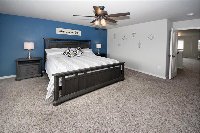 Master bedroom with double doors and ceiling fan