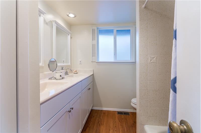 Remodeled Full Bathroom with Dual Sinks and Hardwood Floors.