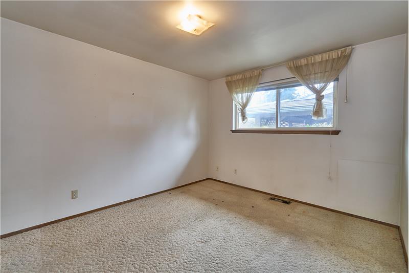 Larger Second Bedroom with Hardwood Floors under the Carpet.