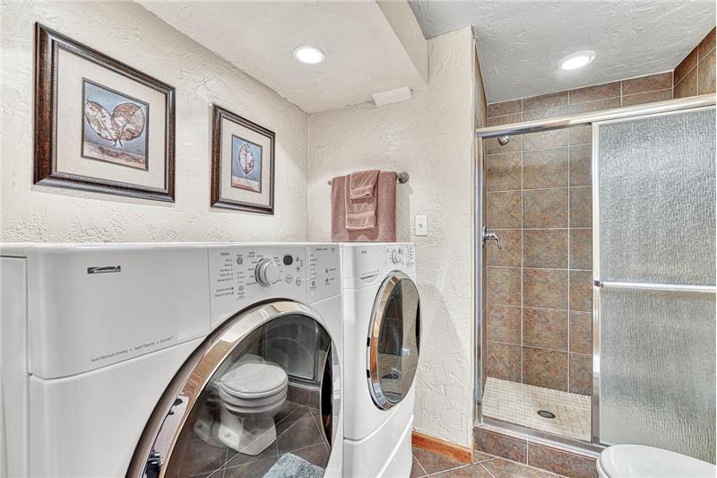 Basement bathroom and laundry area with washer and dryer that stay