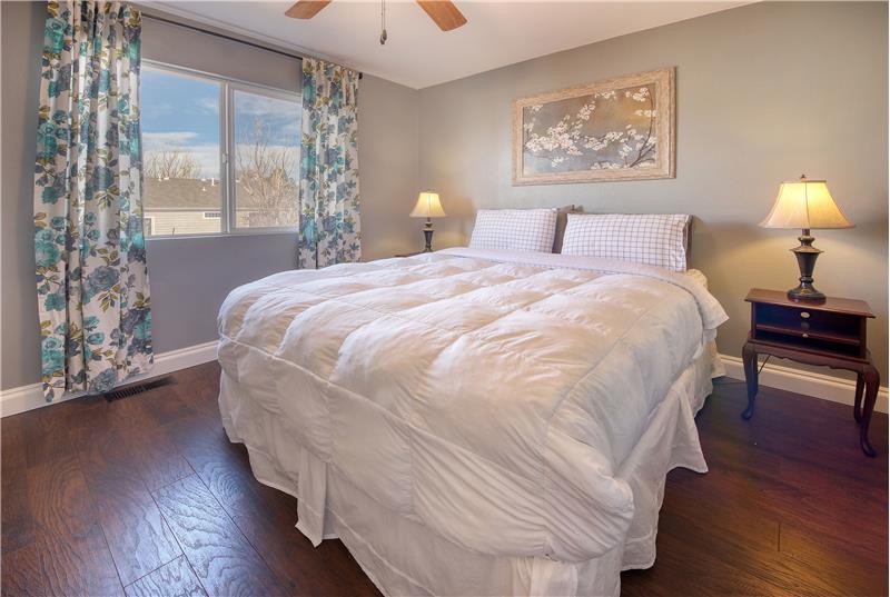 The upper-level Bedroom #2 has luxury vinyl plank floors, a lighted ceiling fan, and walk-in closet