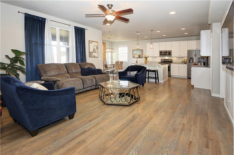 Living room with recessed lighting, ceiling fan, and hardwood flooring